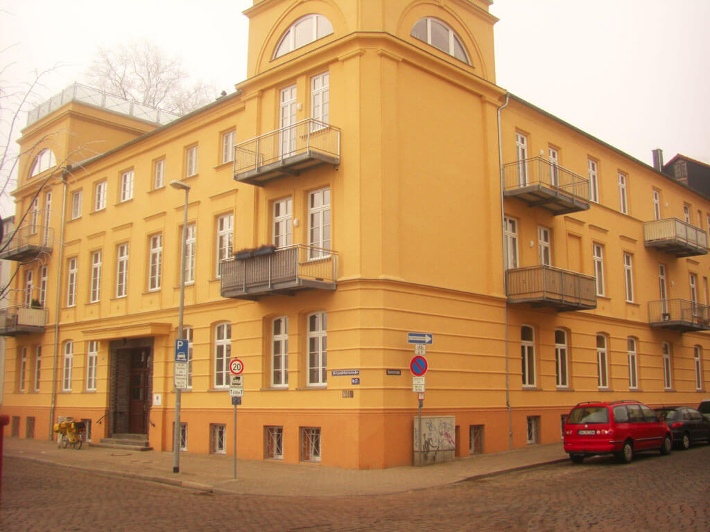 Mehrfamilienhaus in Ecklage mit gelber Fassade